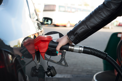 A lady fills her car with gas.