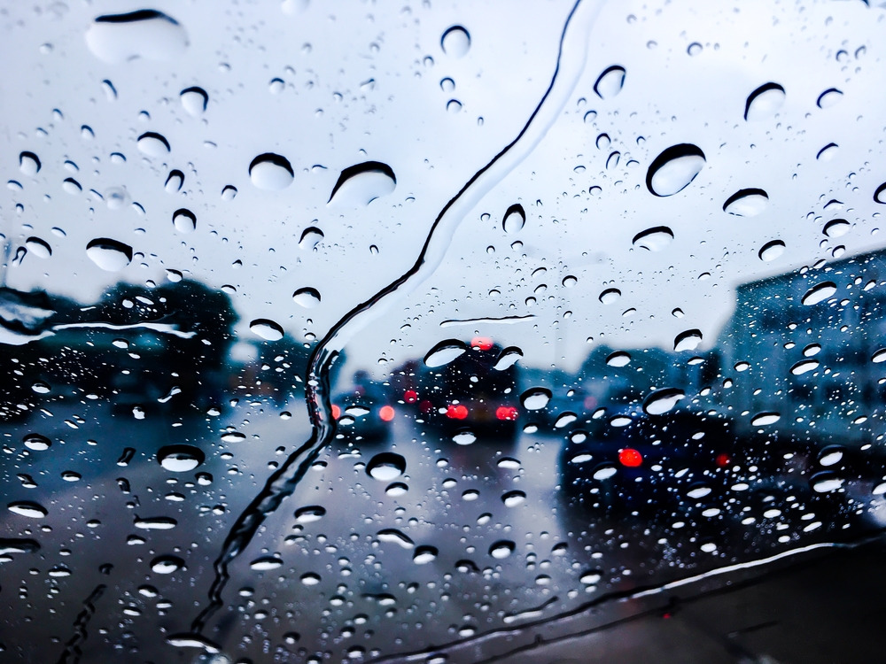 Raindrops hitting windshield in car
