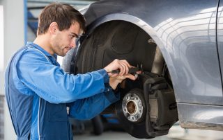 mechanic checks brakes