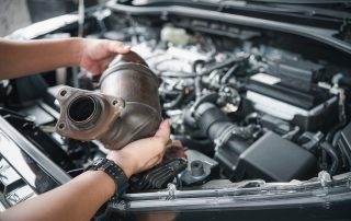 mechanic inspecting muffler from car