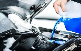 mechanic pours engine coolant into car